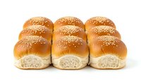 Fresh sesame seed hamburger buns arranged in rows on white background, golden brown bakery bread rolls isolated for food service and restaurant use.