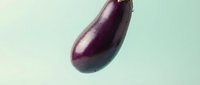 Fresh dark purple eggplant with glossy skin isolated on mint green background, suitable for food photography, culinary design, recipe blogs, and healthy eating content.