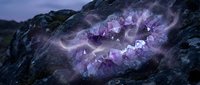 Purple amethyst crystal cluster formation in natural rock cave with mystical lighting effects for spiritual healing meditation and gemstone collection displays.
