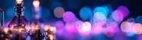 Glowing bokeh lights in pink and blue create magical atmosphere with glass bottle silhouette in foreground, panoramic composition for festive backgrounds.
