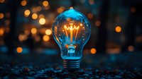 Glowing light bulb with warm filament against bokeh background symbolizing innovation, creativity, and bright ideas for business concepts.