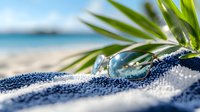 Sunglasses and tropical palm leaves on sandy beach with turquoise ocean background, summer vacation and travel concept for relaxation and holiday getaway.