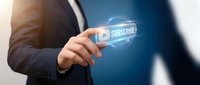 Businessman touching digital subscribe button with glowing effect for online marketing and customer engagement strategies.