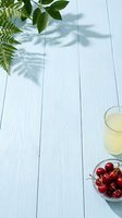Fresh green foliage and ripe cherries arranged on white wooden surface with beverage, ideal for food styling, wellness content, and summer lifestyle designs.