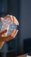 Hands protecting glowing digital network sphere with connected nodes and data points representing cybersecurity, technology innovation and digital transformation.