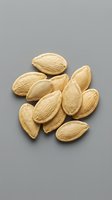 Raw almonds with shells scattered on gray background for healthy snacking and cooking ingredients in kitchen recipes and nutritional content.