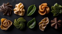 Artisanal chocolate bonbons and pralines with elegant swirls and floral shapes arranged on dark background. Luxury confectionery with green leaf decorations.