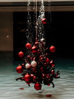 Floating Christmas tree decorated with red and white baubles suspended in air with magical sparkle effect and falling glitter against dark background.