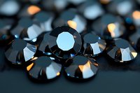 Black diamonds scattered on dark surface with dramatic lighting and reflections creating luxurious sparkle effect. Macro jewelry photography with selective focus.