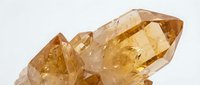 Polished citrine crystal cluster with golden yellow faceted points against white background, suitable for mineral collections, wellness, and gemstone product photography.