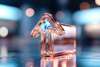 Glass arrow pointing upward on reflective surface with bokeh background in blue and rose gold tones, symbolizing growth, success and direction.