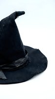 Black witch hat with curved pointed tip and ribbon band isolated on white background for Halloween costume and magical themed designs.