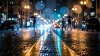 Blurred city street at night with colorful bokeh lights reflecting on wet asphalt pavement creating atmospheric urban scene for backgrounds and mood concepts.
