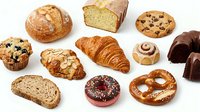 Assorted fresh baked goods including croissants, muffins, bread, donuts and pastries isolated on white background for bakery, cafe and food design projects.