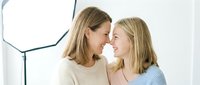 Happy Caucasian mother and teenage daughter sharing intimate moment together, smiling and bonding in bright modern home interior for family lifestyle content.