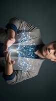 Young man with glowing digital network connections emanating from chest area representing innovation, technology and human connectivity in modern world.