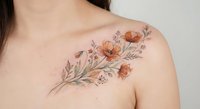 Delicate floral tattoo with orange poppies and botanical elements on woman's shoulder and chest area showcasing feminine body art and ink design.