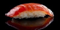 Fresh salmon nigiri sushi with rice on black background with reflection. Traditional Japanese cuisine for restaurant menu and food photography.