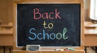 Back to school message written in colorful chalk on classroom blackboard with wooden frame and eraser for educational concepts and academic preparation.