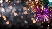 Festive tinsel decorations in purple and gold against blurred bokeh lights background create magical holiday atmosphere for seasonal celebrations.