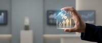 Business professional holding glowing percentage symbol with upward arrows representing financial growth, interest rates, and investment returns in modern office.