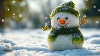 Cheerful snowman with carrot nose wearing green knitted hat and scarf stands in fresh snow during gentle snowfall, creating magical winter atmosphere.