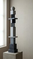 Modern abstract sculpture with stacked geometric shapes in black and white marble creating minimalist tower composition for contemporary interior design.