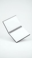 Open blank spiral notebook with white pages standing upright on clean background for office supplies and stationery mockup designs.