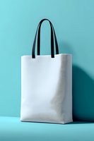 White canvas tote bag with black handles on turquoise background. Eco-friendly shopping bag mockup for branding and promotional designs.