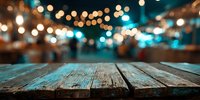 Rustic wooden table with blurred festive night market or street fair with string lights in background.