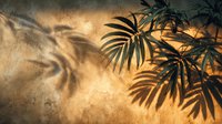 Tropical palm leaves casting dramatic shadows on textured golden sand surface creating warm summer atmosphere for vacation and travel concepts.
