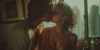 Intimate couple sharing tender moment in warm sunlit bedroom, romantic embrace between young man and woman creating emotional connection for relationship content.