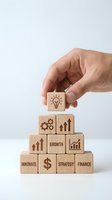 Hand placing wooden blocks with business icons forming pyramid structure representing growth strategy and innovation concepts.