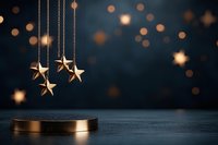 Golden star decorations hanging over metallic podium against dark background with bokeh lights, creating magical festive atmosphere for holiday displays.