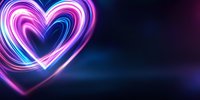 Glowing neon heart shape with pink and blue light trails against dark background creates romantic atmosphere for Valentine's Day designs and love themes.