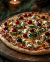 Gourmet pizza topped with cranberries, goat cheese and fresh rosemary on wooden board. Festive holiday meal perfect for Christmas dinner celebrations.