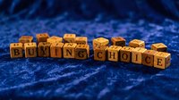 Wooden letter blocks spelling "Buying Choice" arranged on textured blue surface, representing consumer decisions and purchasing options for retail, commerce, and business concepts.