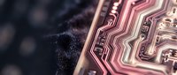 Close-up macro view of copper circuit board traces and electronic pathways on dark textured surface showcasing intricate PCB design and technology components.