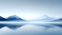 Tranquil mountain lake landscape in soft blue tones with mirror reflection on calm water surface and misty atmosphere creating minimalist nature scenery.
