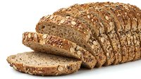 Freshly sliced whole grain bread loaf with seeds and nuts on white background, perfect for healthy eating and bakery concepts.