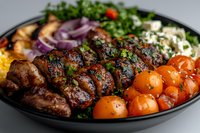 Grilled chicken skewers with roasted cherry tomatoes, fresh herbs, and feta cheese served on black plate with colorful Mediterranean vegetables and garnishes.