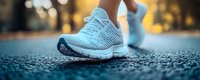 Close-up of athletic running shoes on asphalt during golden hour workout. Modern sneakers for fitness, jogging and sports activities outdoors.