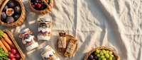 Outdoor picnic spread with wicker baskets filled with fresh fruits, homemade preserves in glass jars, and artisanal treats on white blanket in natural sunlight.