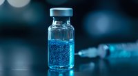 Medical vial with blue luminescent liquid and bubbles on dark background with bokeh effect, syringe in soft focus. Scientific laboratory research concept.