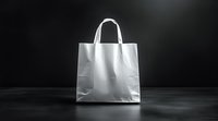 White paper shopping bag with handles on dark background for retail branding and packaging design mockup projects.