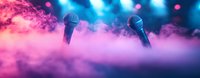 Microphones on stage with pink smoke and blue spotlights creating atmospheric concert environment. Dynamic music performance backdrop with dramatic lighting.