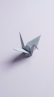 Gray origami paper crane on soft lavender background, isolated and ready for design projects, greeting cards, and creative compositions.