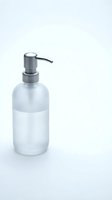 Modern frosted glass soap dispenser with chrome pump isolated on white background for bathroom and kitchen design projects.