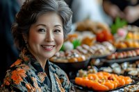 Smiling mature Asian woman in floral kimono at traditional Japanese food buffet with fresh sushi and sashimi platters arranged on dark plates.