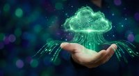 Hand holding glowing green cloud computing icon with digital data streams and network connections on dark tech background for business solutions.
